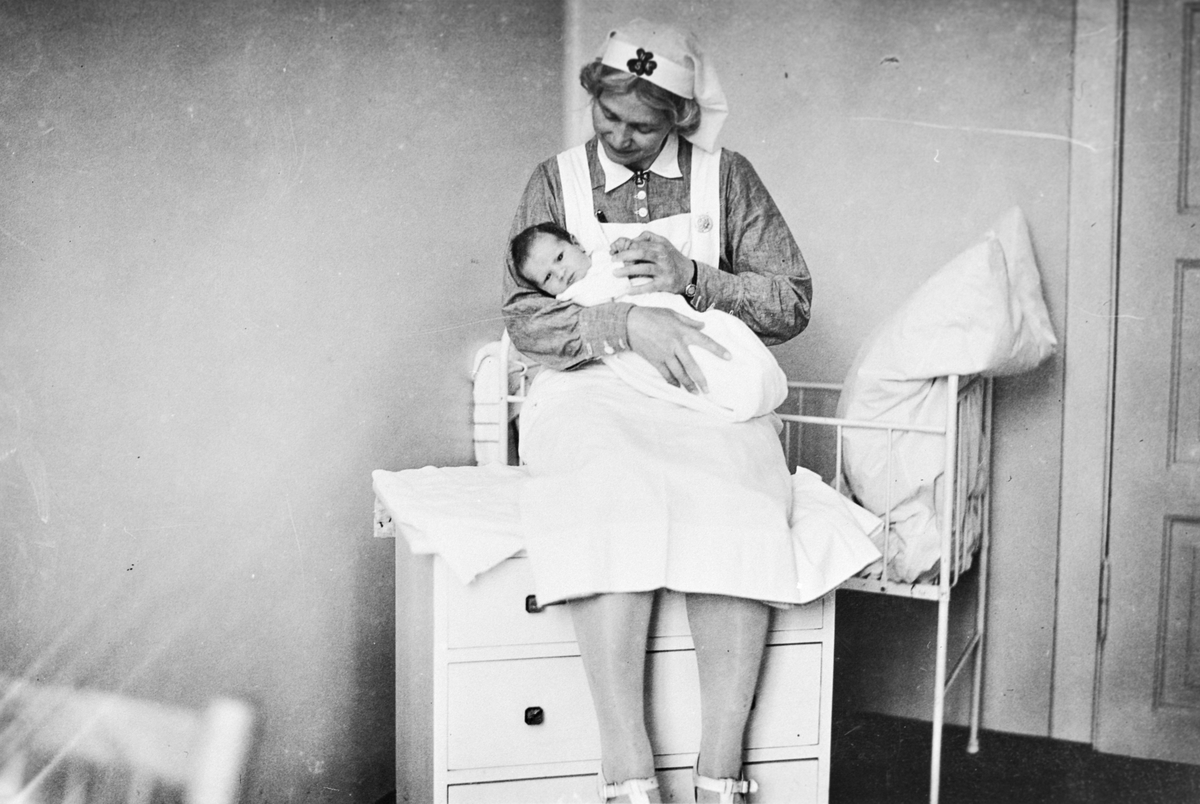 Oversøster Tjodvor Mandt med baby Ottar Christensen på Odda sjukehus.