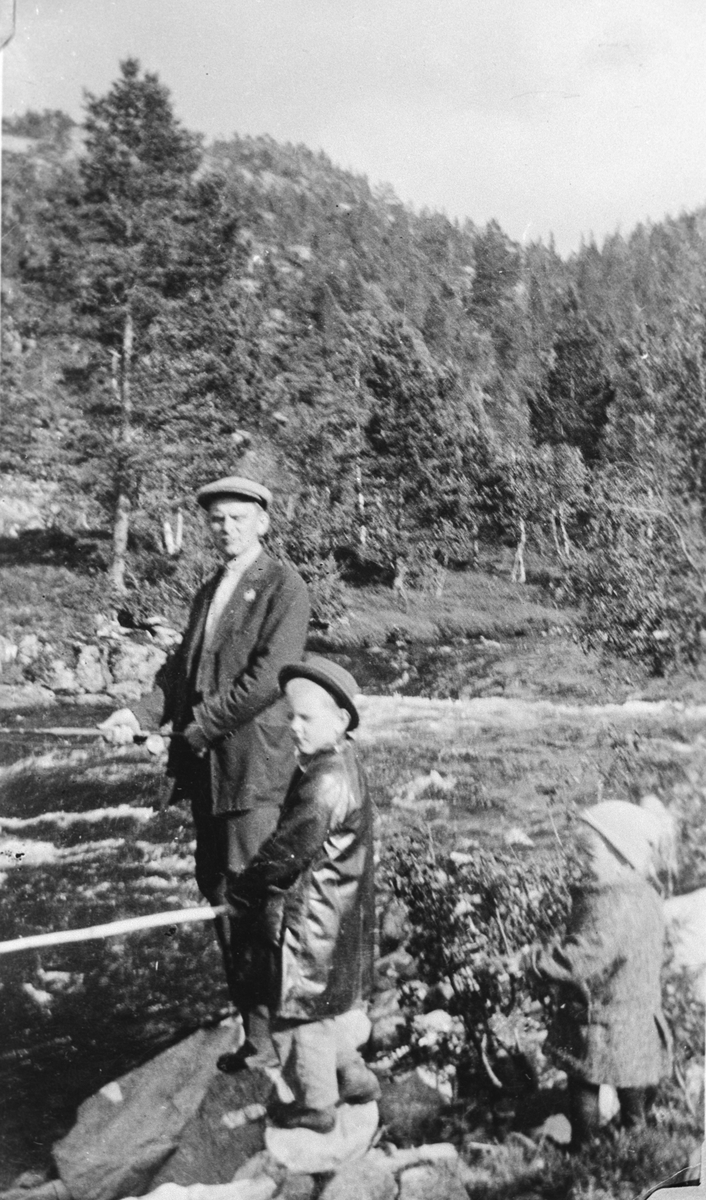 Far og søner fiskar i ei elv på Smørtjønnsmoen.