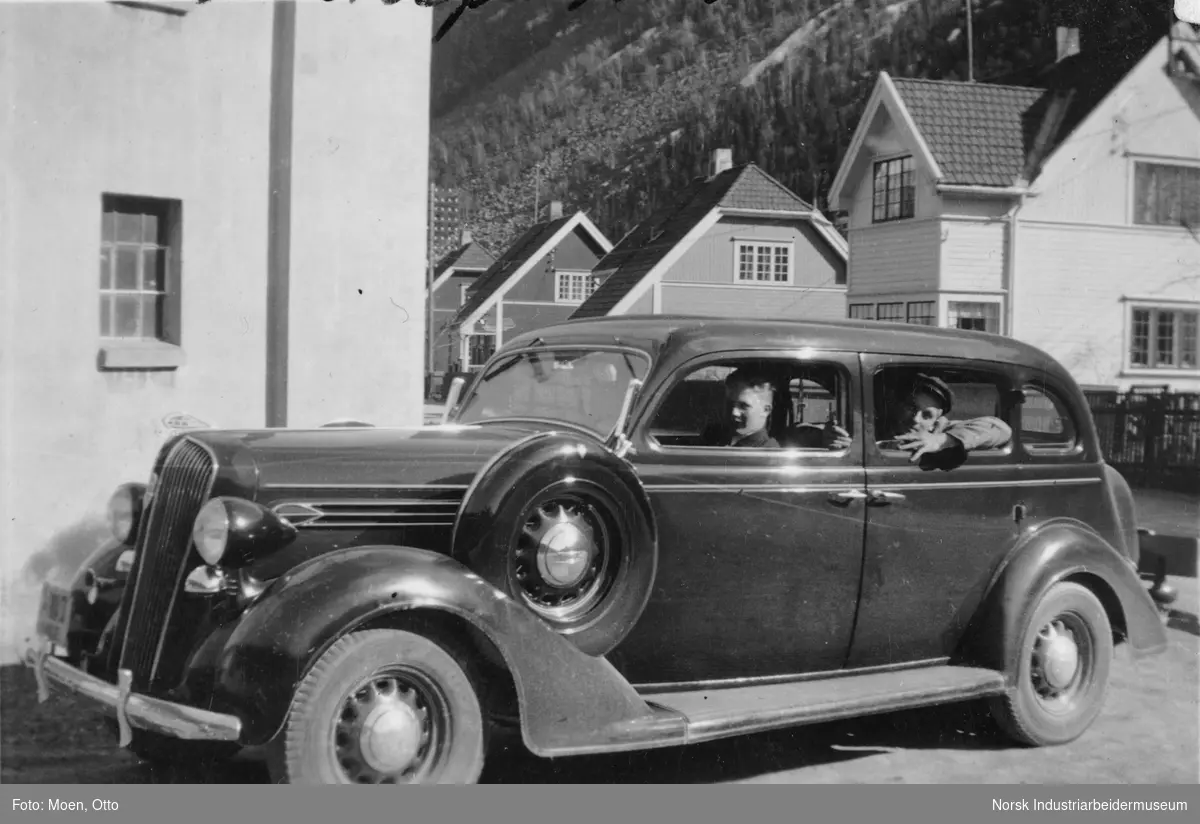 Drosjeholdeplassen ved Tinn Cafe. Hans Øverland i baksete og Asbjørn Myrvoll er sjåfør i Plymouth 1936 modell 7-seter.