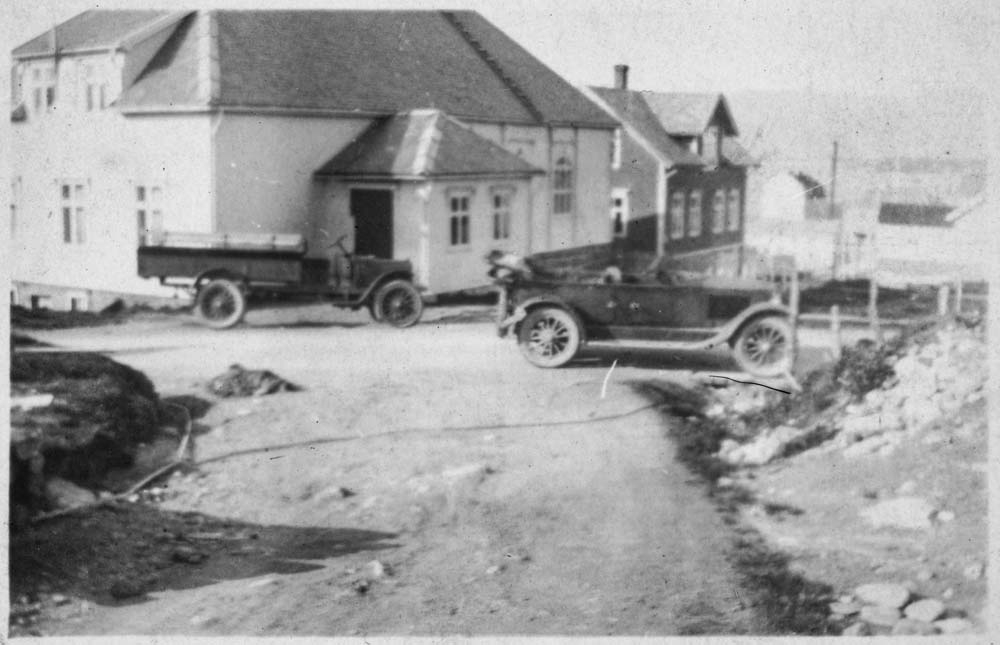 Motiv med to biler og to hus. Kan være tatt i Brønnøysund.