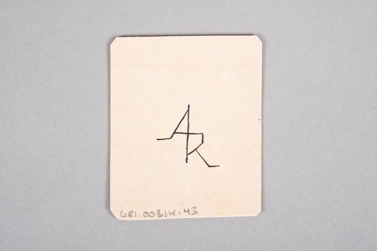 Håndlaget kort med påført tall og rutersymbol. På baksiden av kortet er det et monogram av initalene "AR".