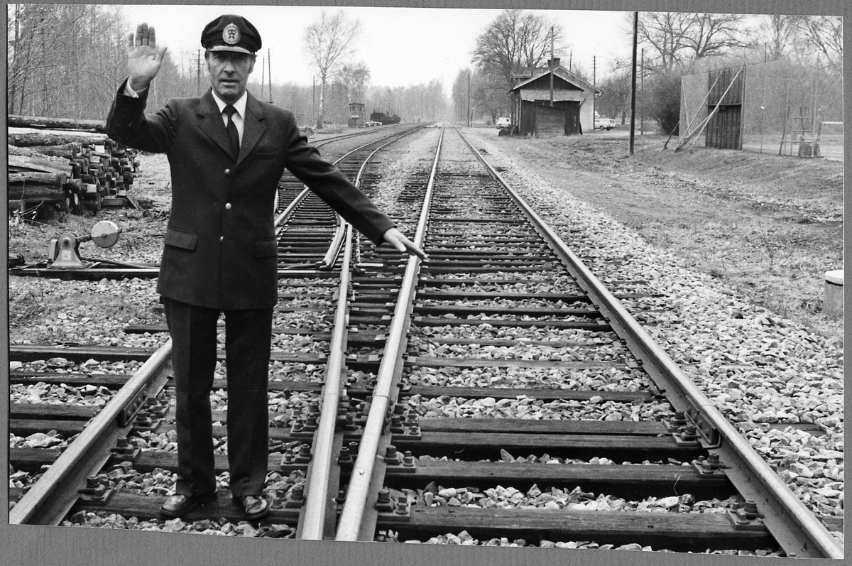 Förste järnvägsexpeditör Pelle Drott visar klart för normalspår och stopp för smalspår vid Jenny station 26/4 1980, under den då pågående arbetsmarknadskonflikten.