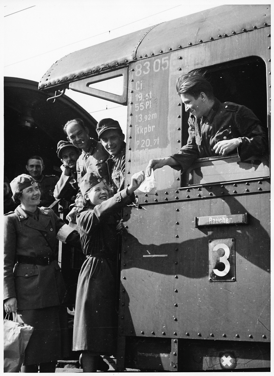 Röda korssystrar besöker skadade tyska soldater som är ombord på ett tyskt sjukvårdståg i Hallsberg under Andra Världskriget.