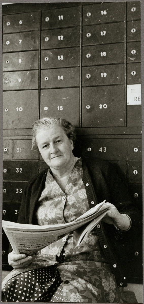 Kvinna framför postboxar i väntsalen på Rekarne station.