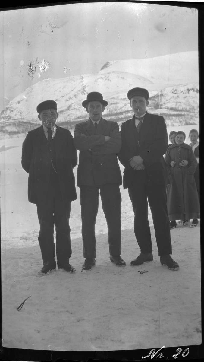 Gruppeportrett av tre menn tatt ute en vinterdag.