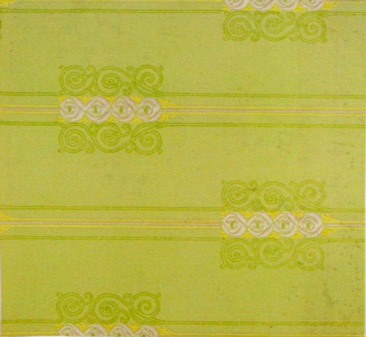 Randmönster med stiliserade rosor/ornament i diagonalupprepning. Tryck i vitt och gult samt i två gulgröna nyanser på ett ofärgat papper.
