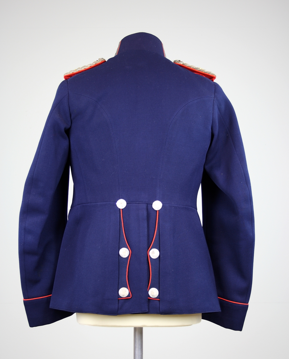 Vapenrock m/ä av blått kläde med överstelöjtnants gradbeteckningar. Axelklaffar och släpspänne avtagbara.