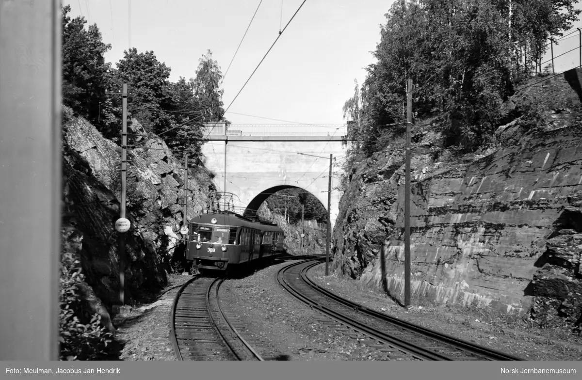 Kolsåsbanentog med motorvogn nr. 308 fremst på vei gjennom Jar-skjæringa inn mot Jar stasjon.