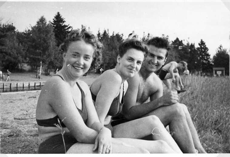 Två unga kvinnor och en ung man i badkläder, förmodligen vid en badstrand. Mannen är sannolikt E A Simi.