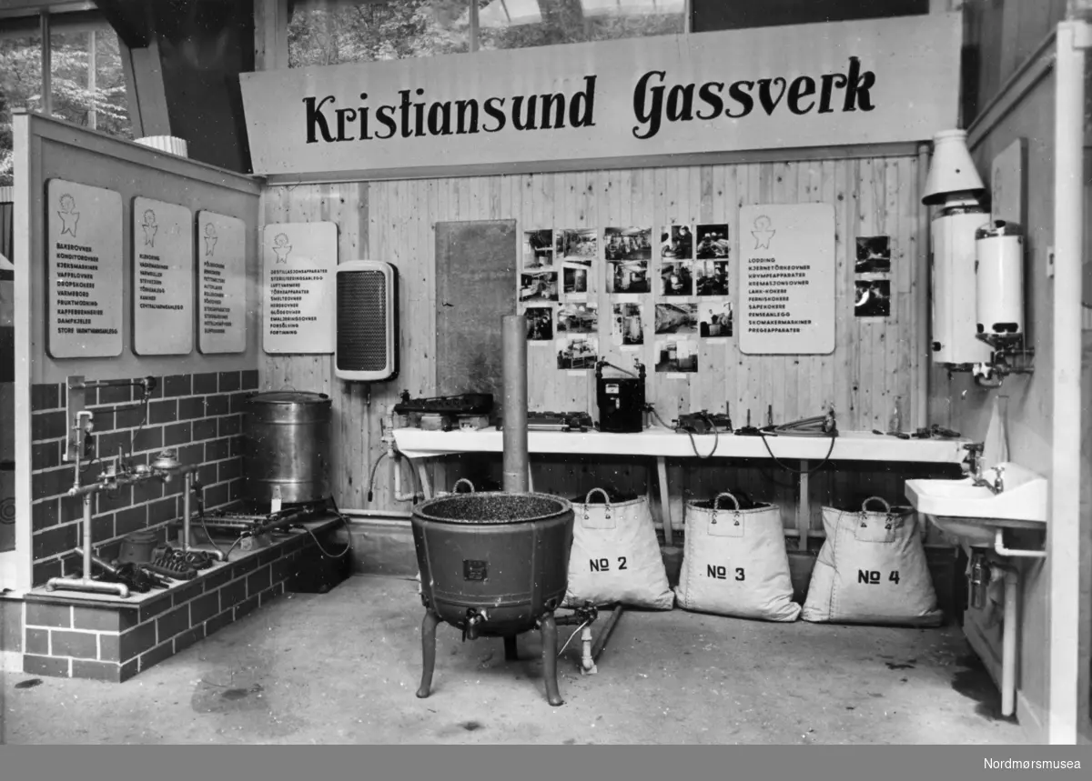 Foto fra det som ser ut til å være fra en utstilling for Kristiansund Gassverk. Fotograf og dateringFra Nordmøre museums fotosamlinger.