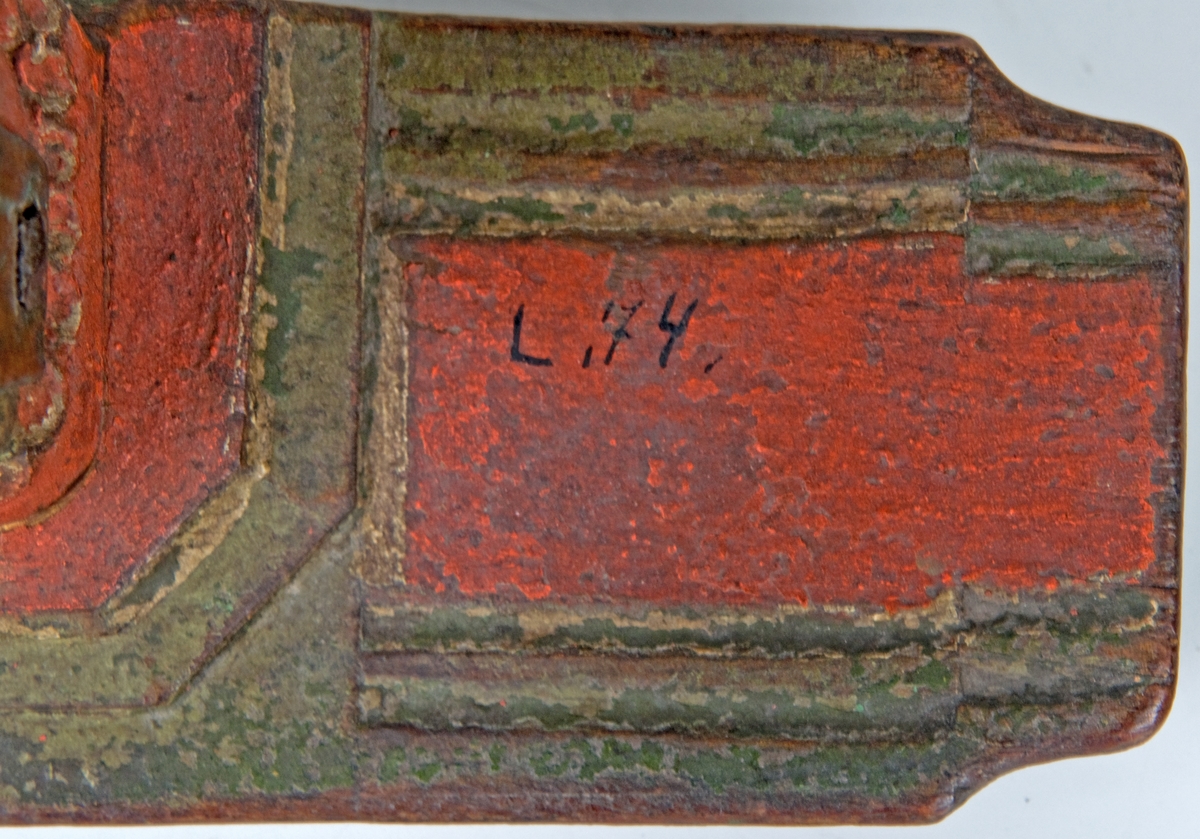 Selkrok, mindre av trä, utskuren och målad i grönt och rött. På bågens underkant ristat 1767.
Snidad repstav. Klackar av trä fästa i bågens ändar. 
Bred och kort.