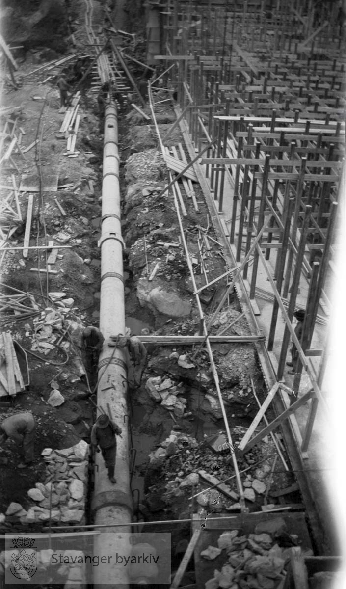 Legging av rør...Vann fra Store Stokkavatn ble pumpet opp til bassenget på Tjensvollhøyden 89 m o.h.Stokkavatnanlegget startet opp i 1930 og fra da stilnet pumpene i Egenes brannstasjon. Stokkavatnet var byens vannreservoar fram til 1959.