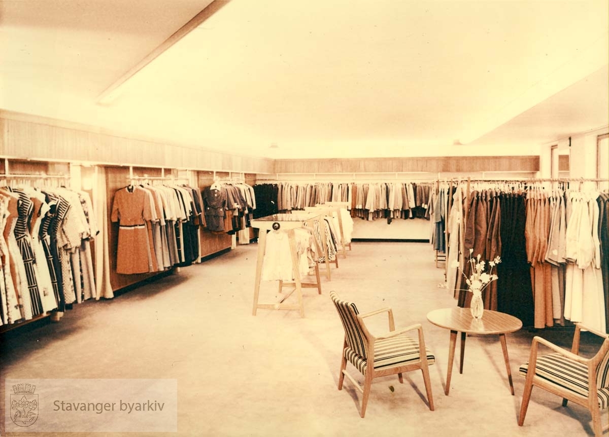 Norem Baades konfeksjonsavdeling i Kirkegaten, butikkinteriør, kjoler og drakter, kåper. Stoler og bord. Utskilt fra PA293.