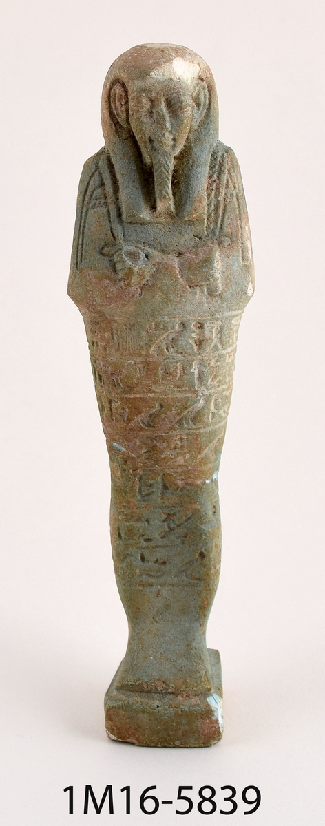 Statyett föreställande faraon med hieroglyfer i beige-grön sten.