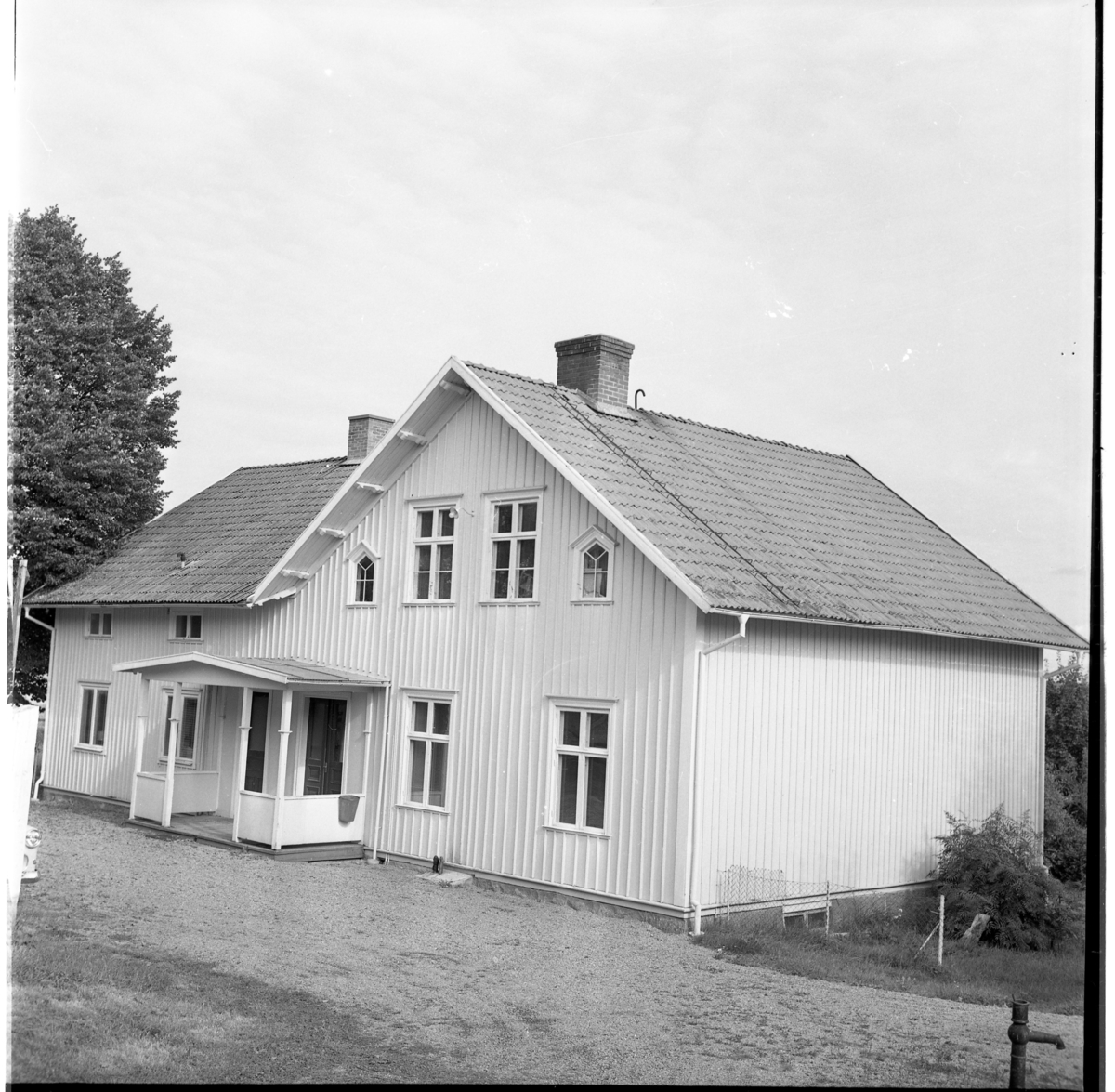Folkskolan i Ölmstad. En större byggnad med veranda och locklistpanel.