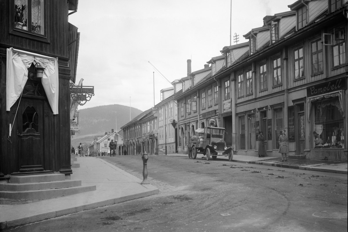 Storgata, Lillehammer. Frisenberg-hjørnet med Hellebergs forretning på østsiden. Lastebil D-140 parkert utenfor Helleberg