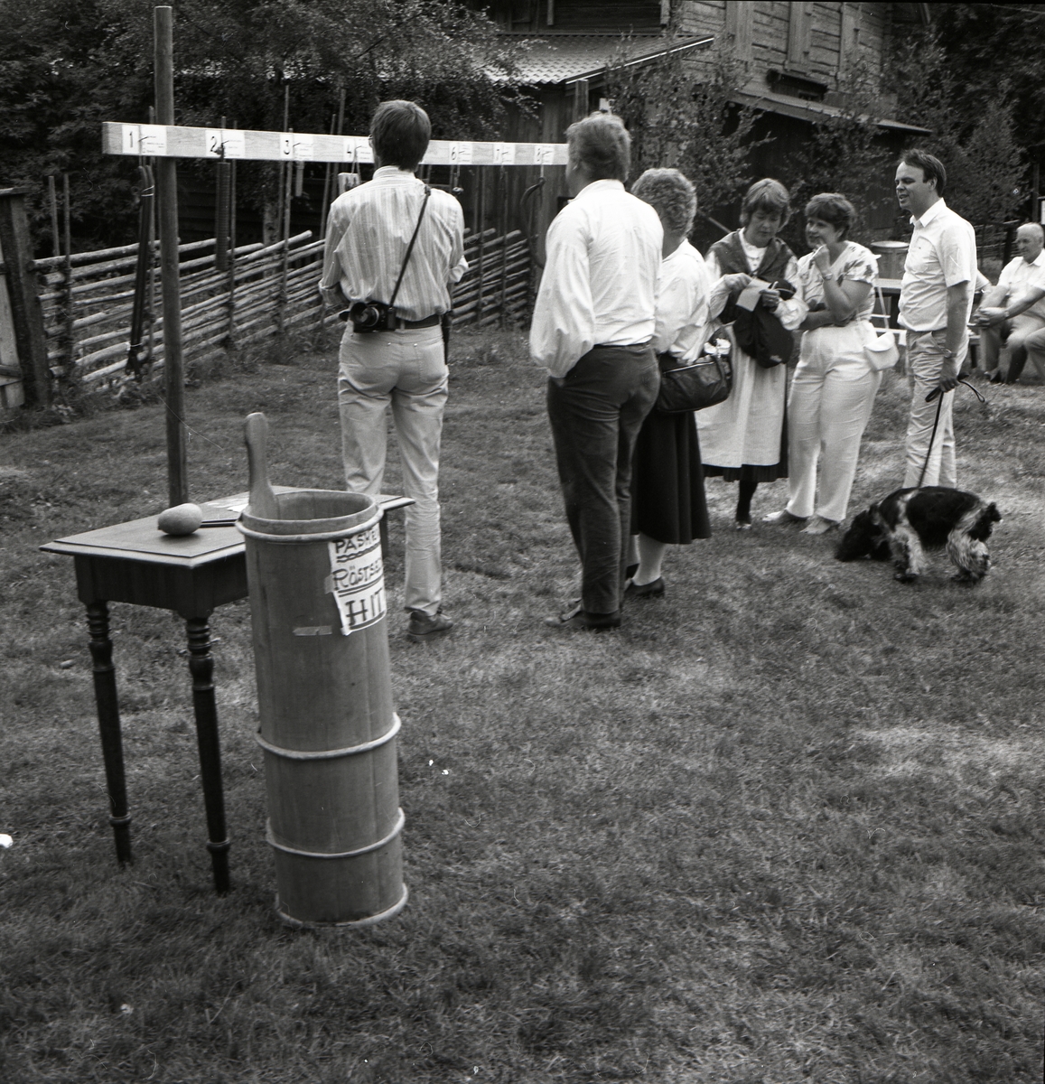Folksamling studerar numrerade föremål som hänger från en planka under Rengsjöfesten, 14 juli 1985.
