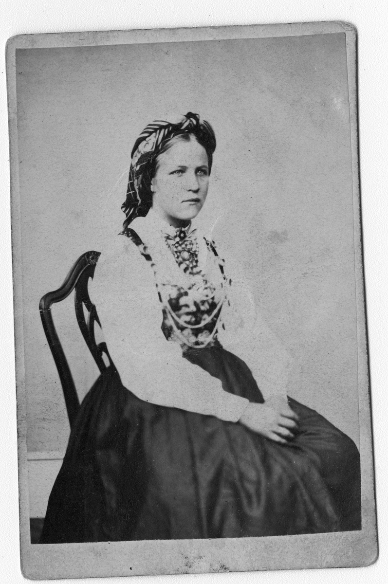 Fotosamling etter fotograf Knut Aslaksen Berdal. f. 1829 Einlaugdalen Vinje, d. 21.01.1895. Portrett av Anne Torjusdotter Lundvall f 1850 i folkedrakt. Gift med Halvor Sveinungsen Groven. Hun døde ung. De bodde på Midtsund
