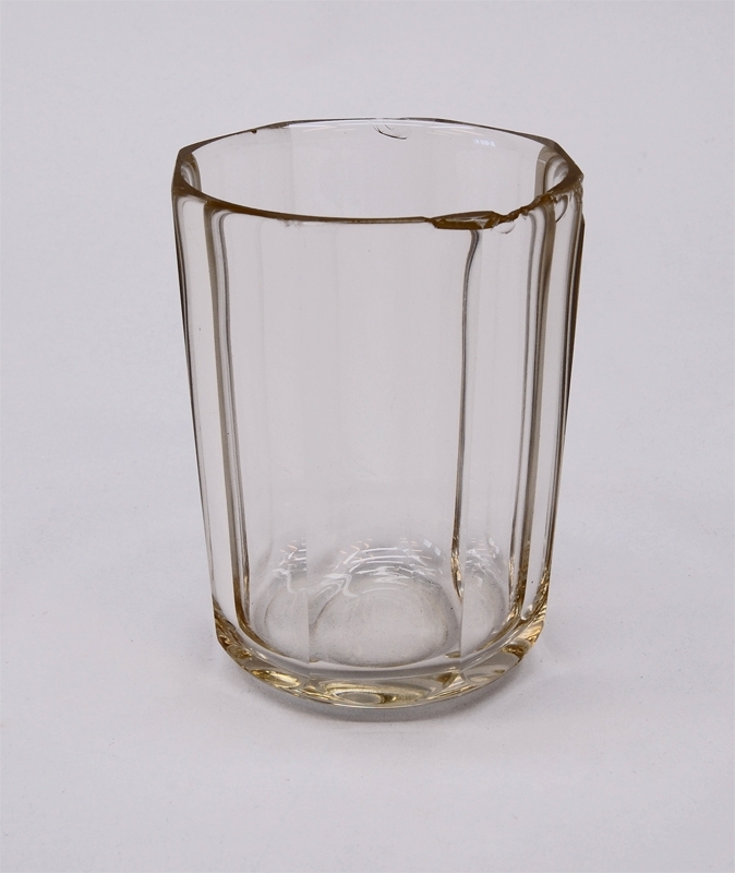 Dricksglas av genomskinligt glas. Det är åttkantigt och rundas av längst ned vid botten.