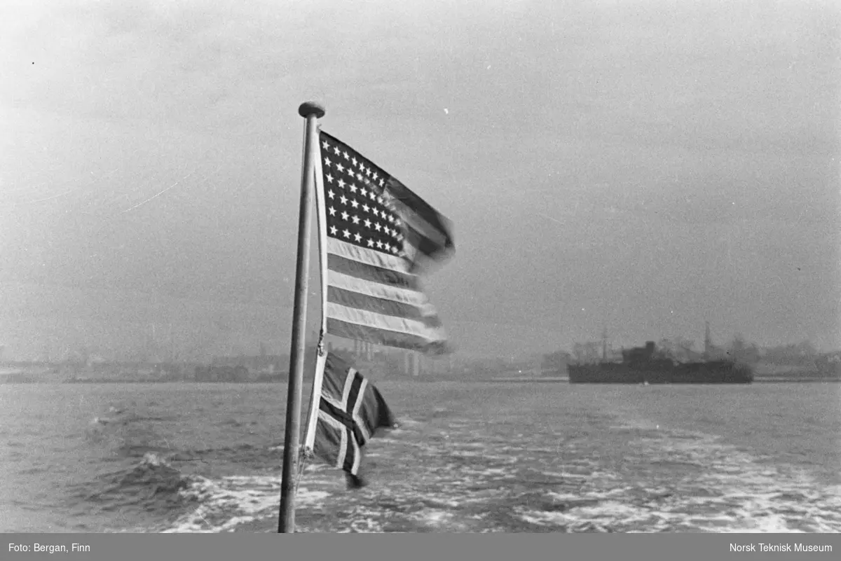 Flagg amerikansk og norsk mot skjølvannet av et skip