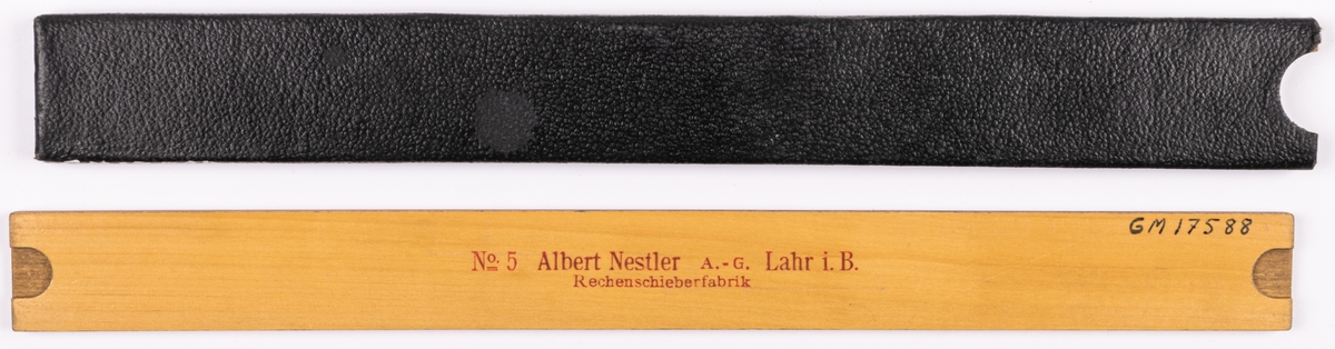 Räknesticka av lövträ med vitmålad framsida. Förvaras i svart läderimiterat pappetui. På stickans baksida "No 5 Albert Nessler. A-G Lahr i B. Rechnen schiberfabrik.