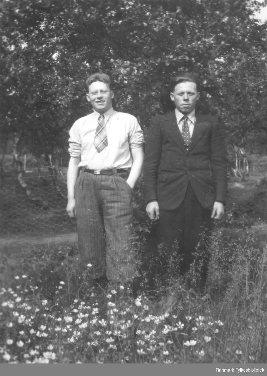 To brødre i penklær fotografert i en eng, sansynligvis i Nesseby kommune.