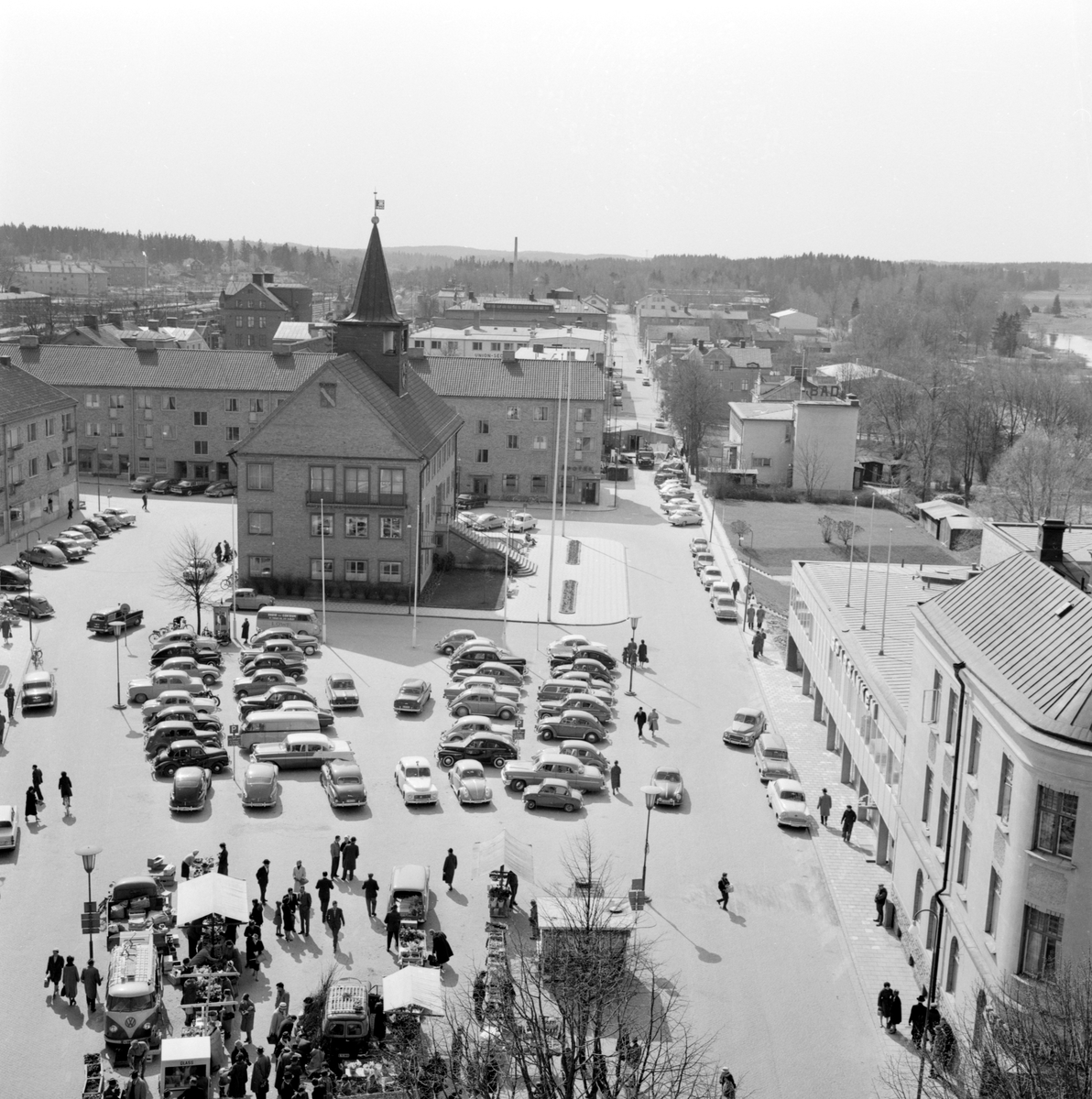 Fotografen Arne Gustafsson har tagit posto i kyrktornet för den här vyn över Stora torget i Mjölby. Året är 1961.