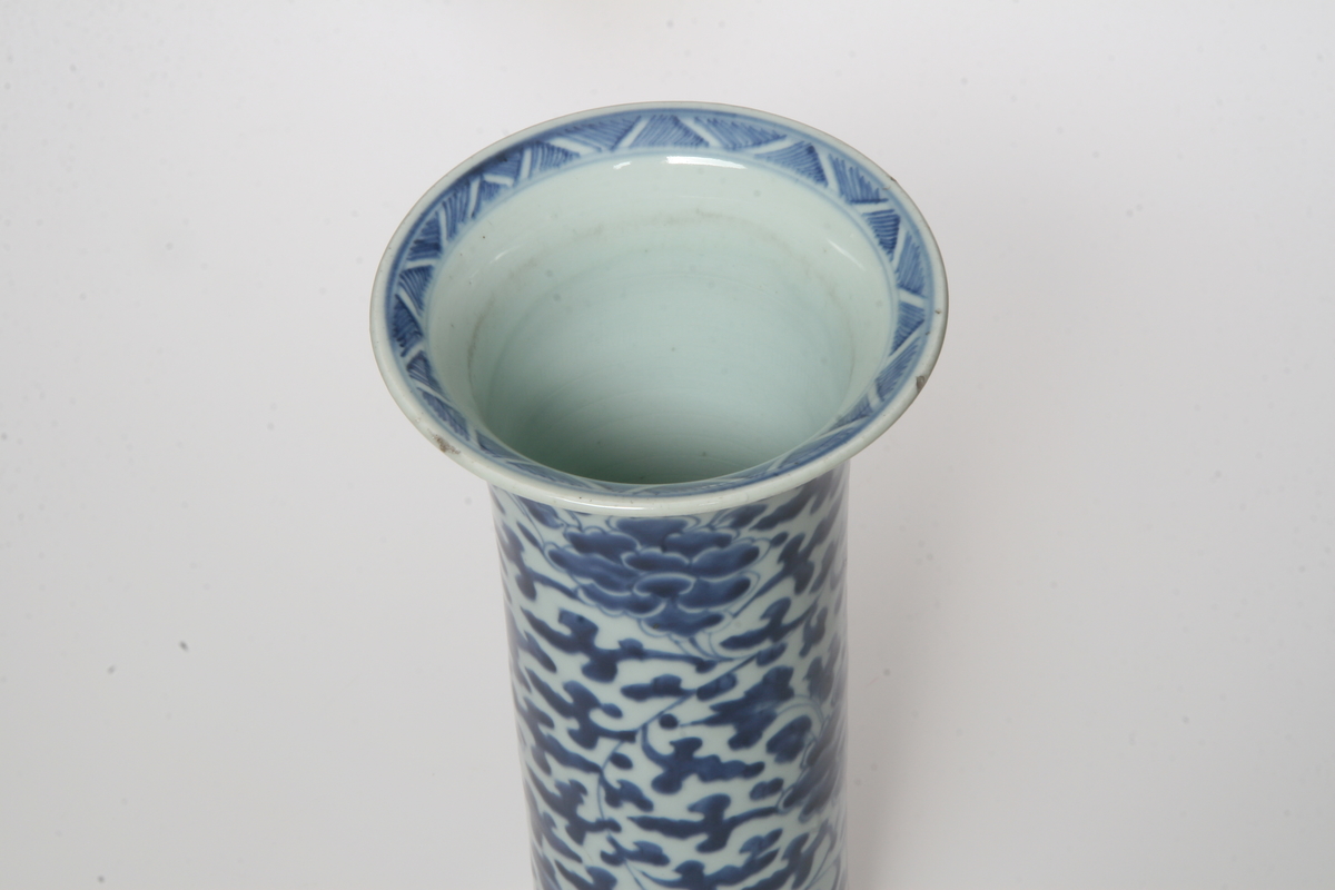 Porselen, sylinderisk, utsvunget oppe og nede, mørkeblå blomsterranker på lyseblå bunn. Samme som AS.310601-AS.310602.