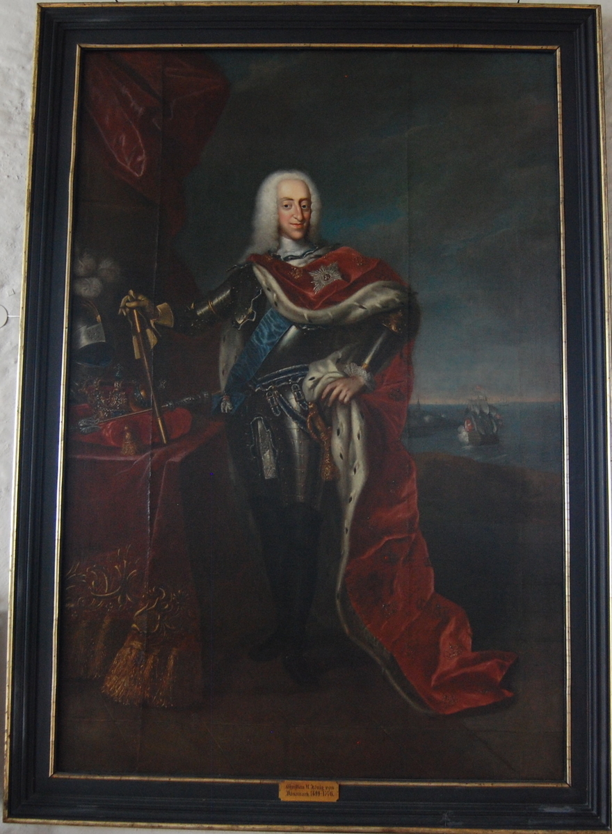 Portrett i helfigur av Christian VI ikledd rustning med rød kappe med hermelinpels. Sjølandskap i bakgrunnen. 