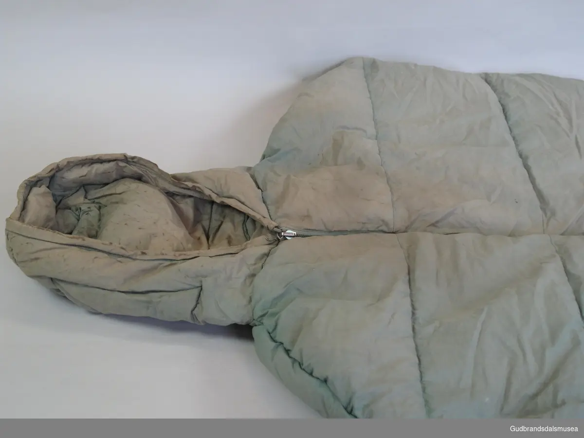 Dunsovepose med hette. Glidlås i to tredjedeler av soveposens lengde.
