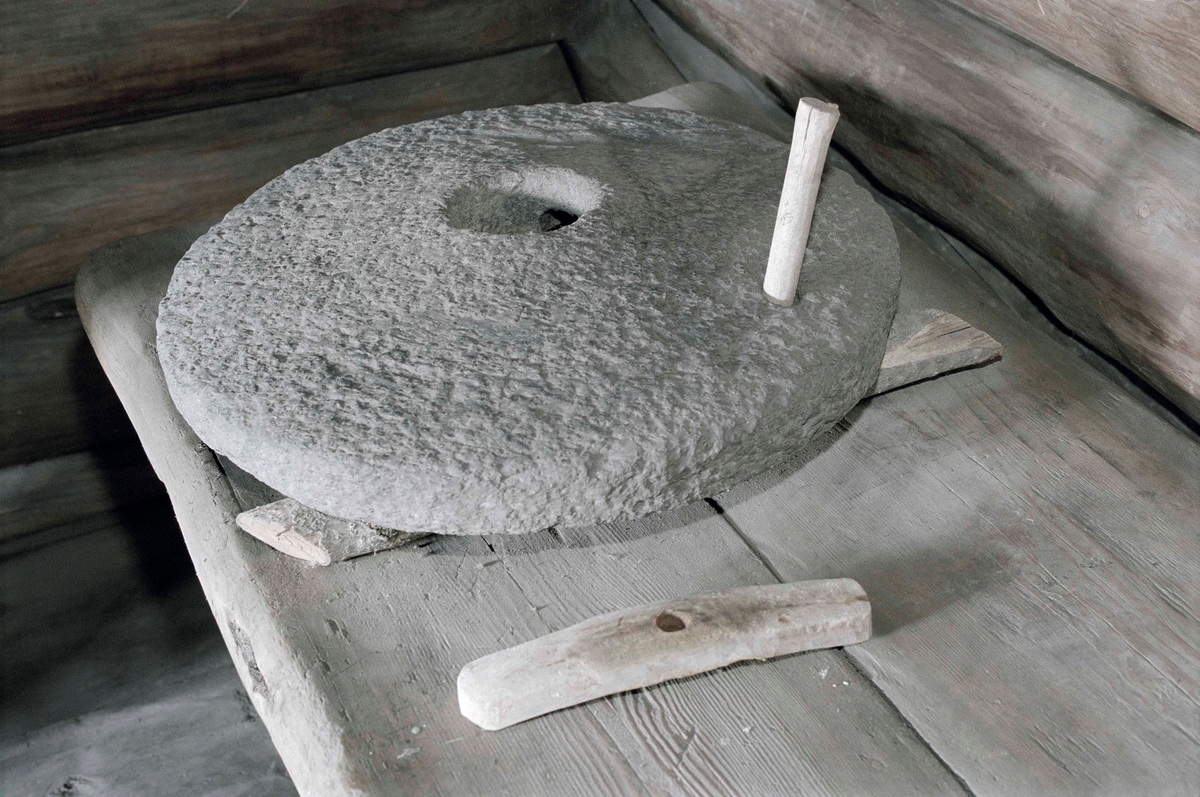 Handkvarn i form av en rund sten, välvd, samt ett runt hål mitt i. Segel av trä, rektangulärt med hål. Sekundärt draghandtag. Underliggare saknas.