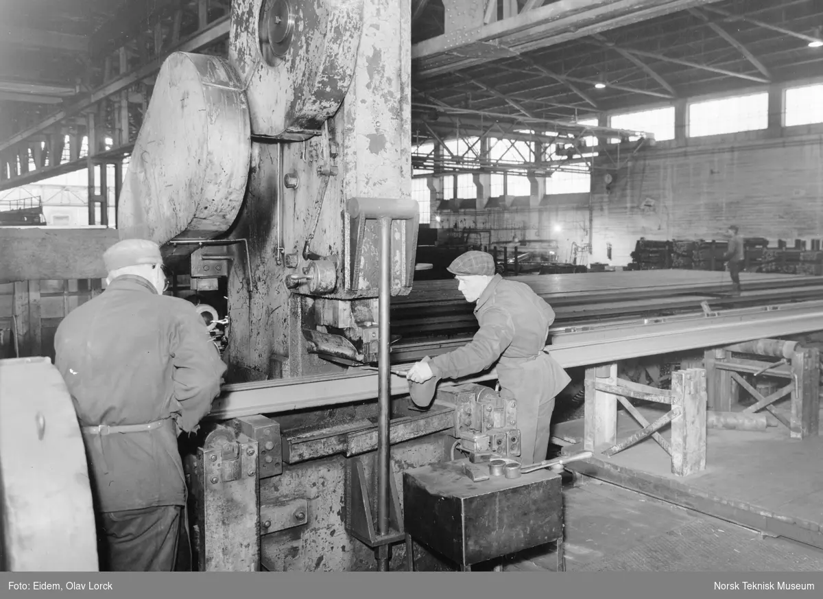 Retting av skinner i skinnerettepresse i jernlager 1-2, Christiania Spigerverk. Til høyre ser vi Håkon Dalsglev i arbeid.