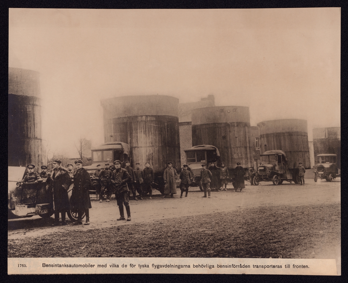 Bilden visar en kolonn med tankbilar samt tillhörande personal som lastbilschaufförer och bevakning. Tankarna är utformad som oljecisterner.