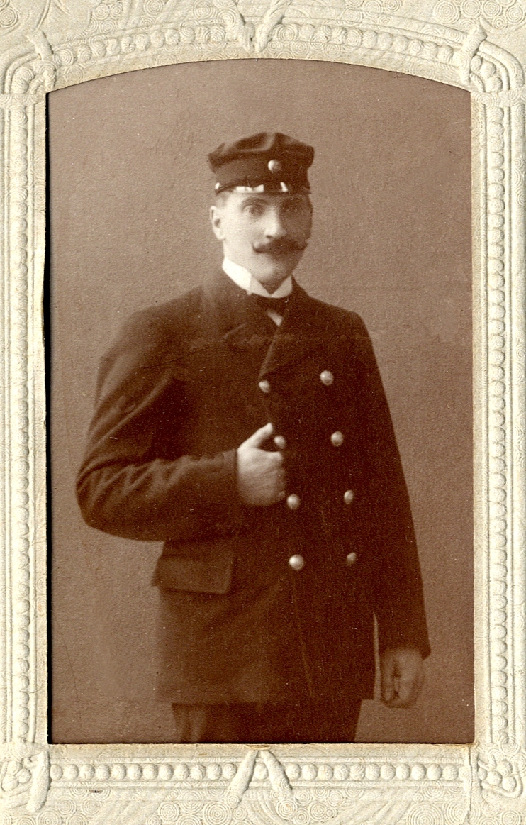 Foto av en man med mustasch, klädd i sjukskötareuniform med stärkkrage. Troligen anställd på S:t Sigfrids sjukhus, Växjö. 
Knäbild, halvprofil.