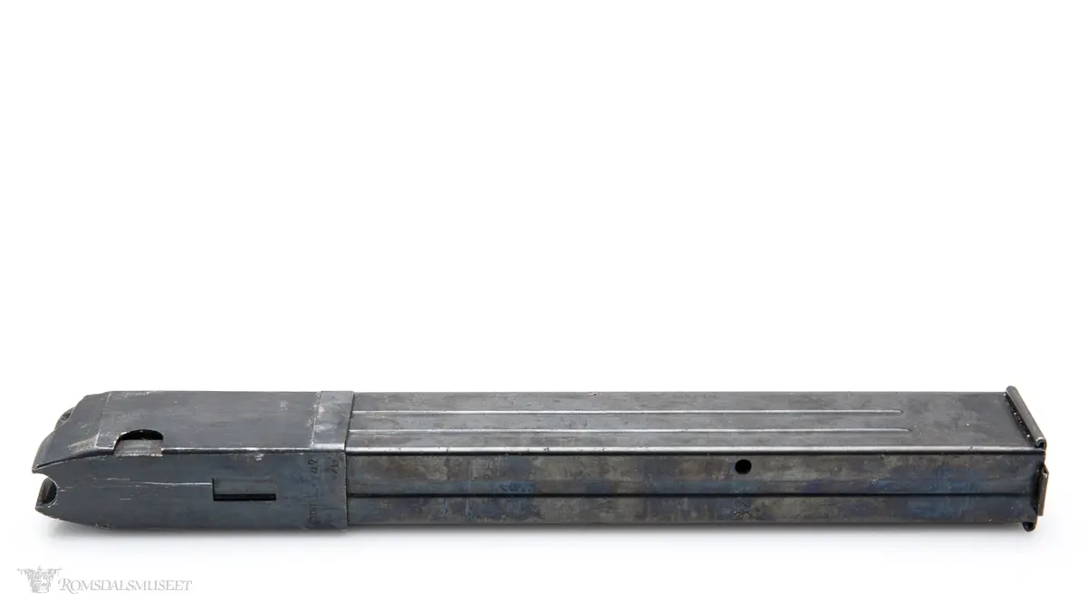 Rektangulært stavmagasin i stål med trykkplate og fjær, tilhørende maskinpistol MP38/40. Magasinet tar 32 patroner.