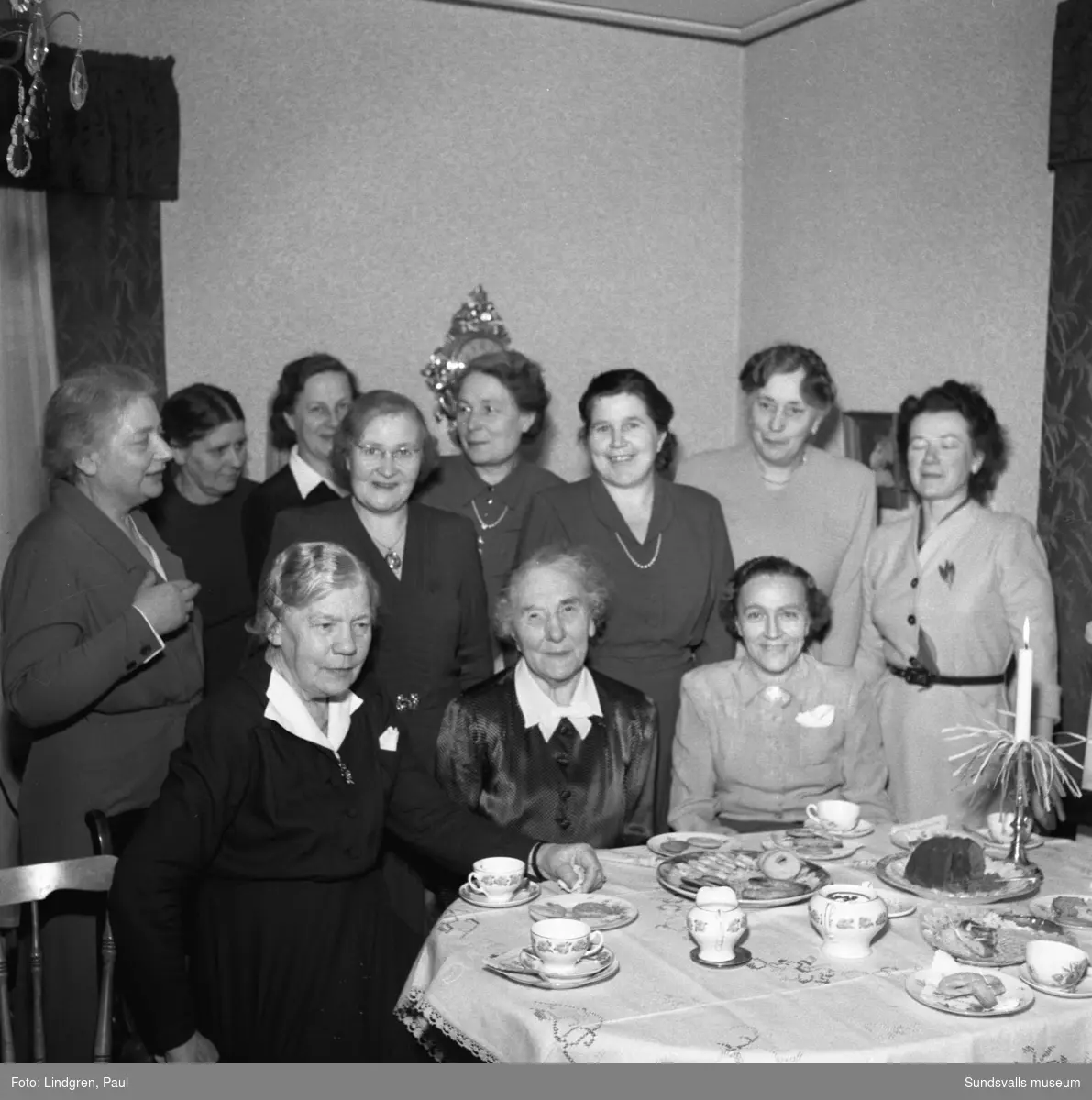 Sjuksystrar för 50 år sedan. En träff med f. d. elever och arbetskamrater vid Sundsvalls lasarett hemma hos sjuksköterskan, fröken Hanna Öfvergren (snart 80 år) på Örnsköldsallén. På bild 2 ses sjuksöterskorna (från vänster) Astrid Lind-Johansson, Kerstin Dahlin och längst till höger Elsa Flensjö. I mitten sitter fröken Hanna Öfvergren omgiven av sina forna elever.