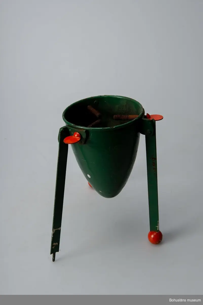 Julgransfoten består av en grön behållare för vatten och tre röda bladskruvar för fastsättning av gran. Tre hopfällbara ben med röda knoppar i ändarna, en saknas.