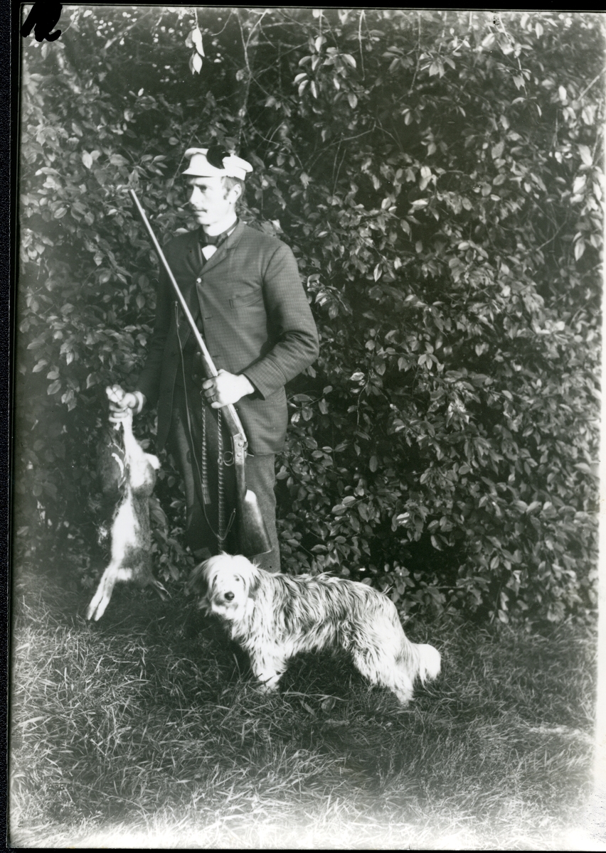 Möklinta sn, Sala.
Man med hund, bössa och jaktbyte. Början 1900-tal.