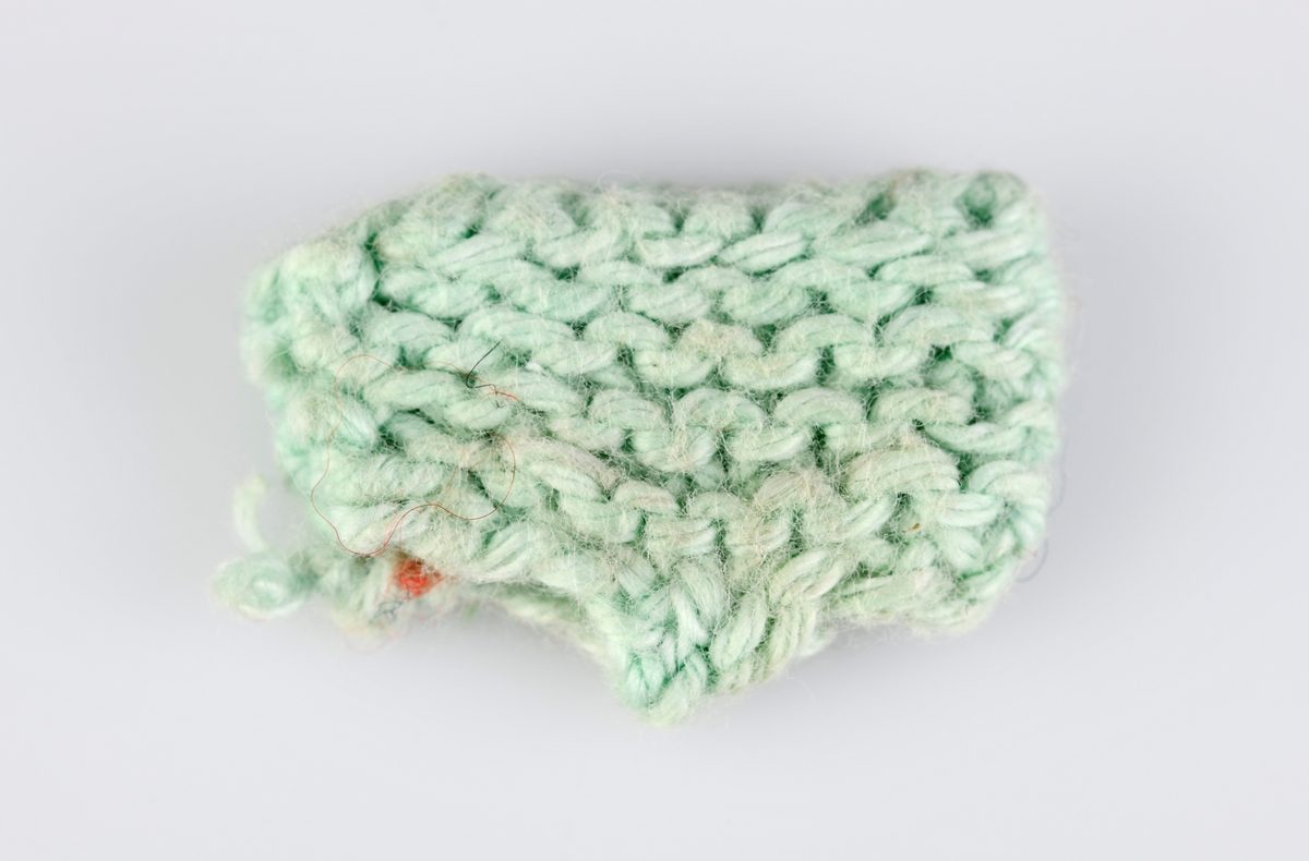 En strikket truse til dukke. Den er strikket i lysegrønt bomullsgarn og i rillestrikk. Den har "normal" trusefasong.