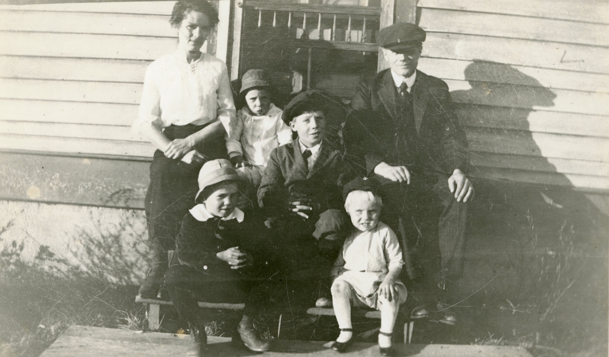 Gruppeportrett av en familie foran et hus i Amerika. Slektninger av Skjeldrup.