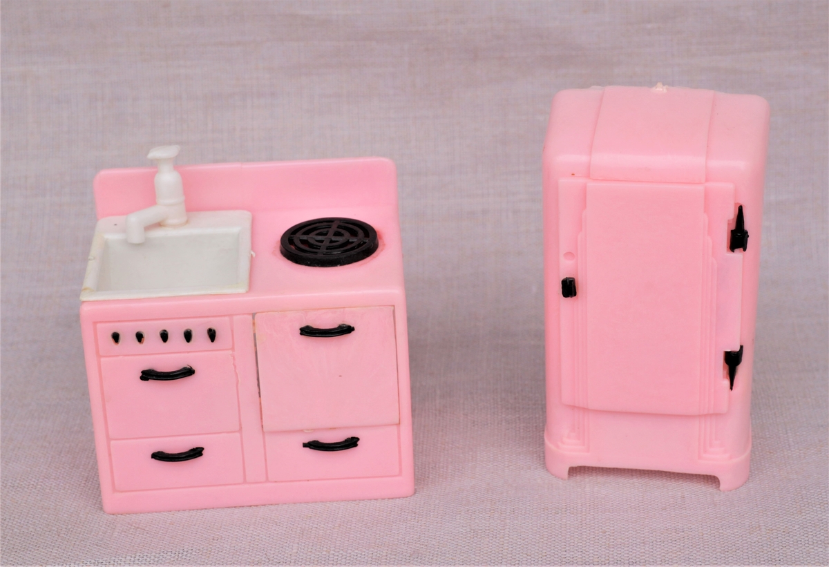 Rosa kjøkkeninventar av plast. Ett kjøleskap og en kombinert komfyr og vask med skuffer.