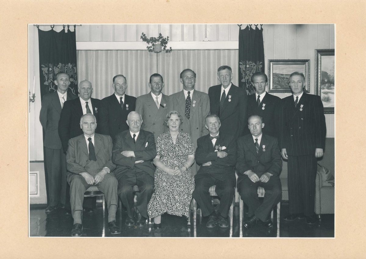 Gruppebilde med en kvinne og 12 menn i forbindelse med at 8 av mennene har fått utdelt Det Kongelige Selskap for Norges Vels medalje for lang og tro tjeneste.