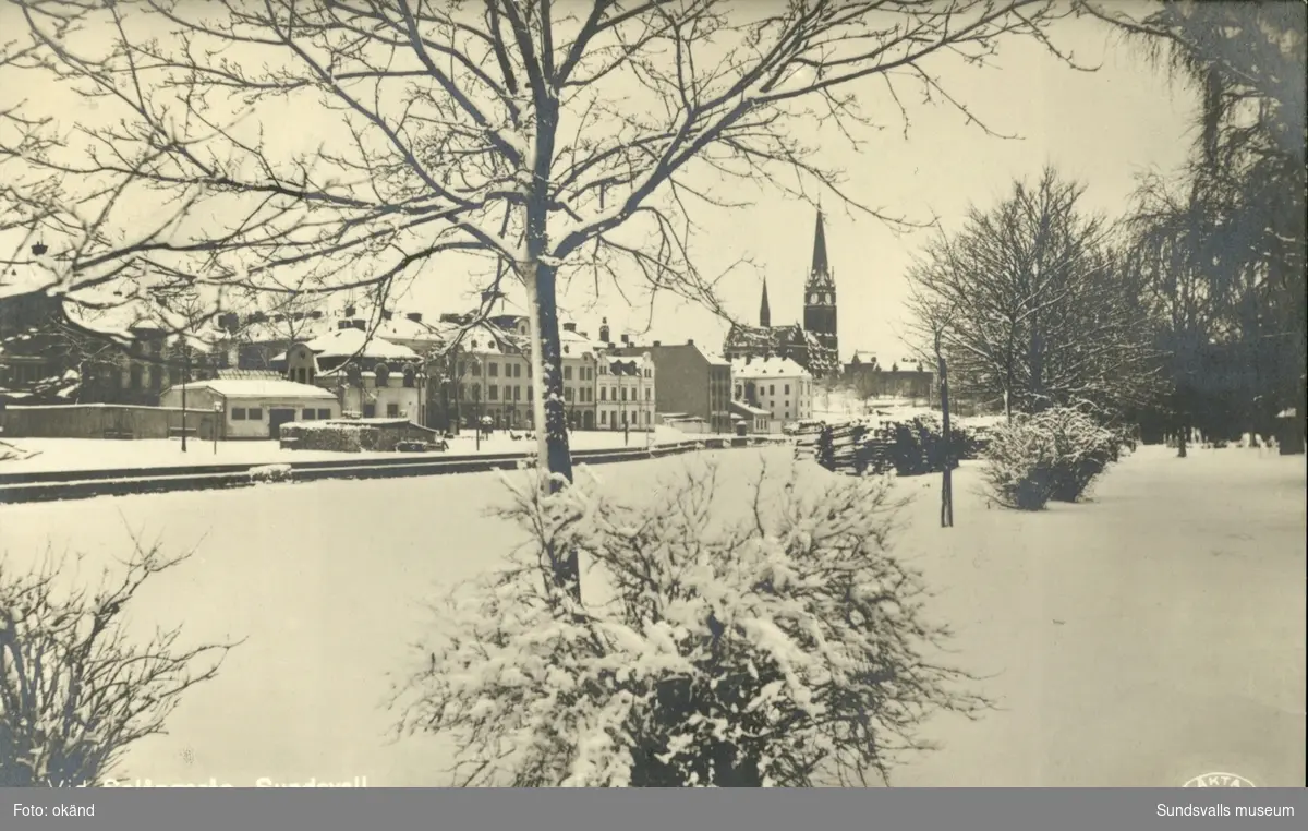Vykort med vintermotiv över Selångersån med Gustav Adolfs kyrka i bakgrunden.