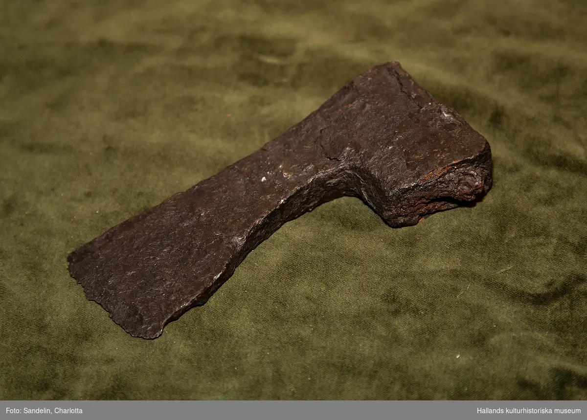 Arkeologiskt föremål. Mått: 16,5 x 6 cm. Yxhuvud av järn. Längd 16,5 cm. Bredd (eggens) 6 cm.