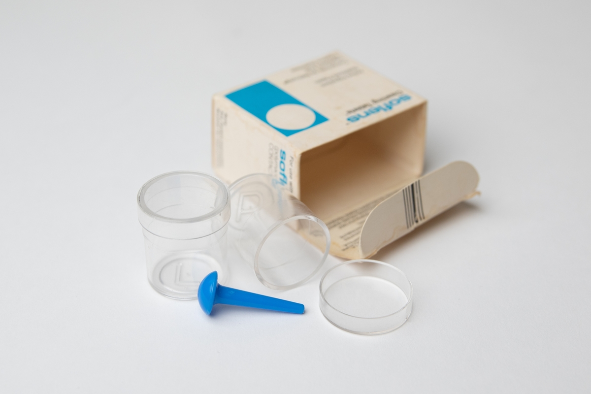 Blandflaskor, ett par, av genomskinlig hårdplast, för rengöring av kontaktlinser tillsammans med rengöringstablett och färskt destillerat vatten (rekommendation en gång i veckan). Flaskorna är märkta i botten med bokstaven R (höger) respektive bokstaven L (vänster). Till flaskorna hör också en blå "linsupptagare" av plast. Flaskorna förvaras i en tom tablettförpackning av papper (soflens Cleaning Tablets), daterad september 1979.

JM 56610:1, ett par blandflaskor (2 st flaskor) och en "linsupptagare" 
JM 56610:2, tom tablettförpackning (förvaringsask för flaskorna och "linsupptagaren)