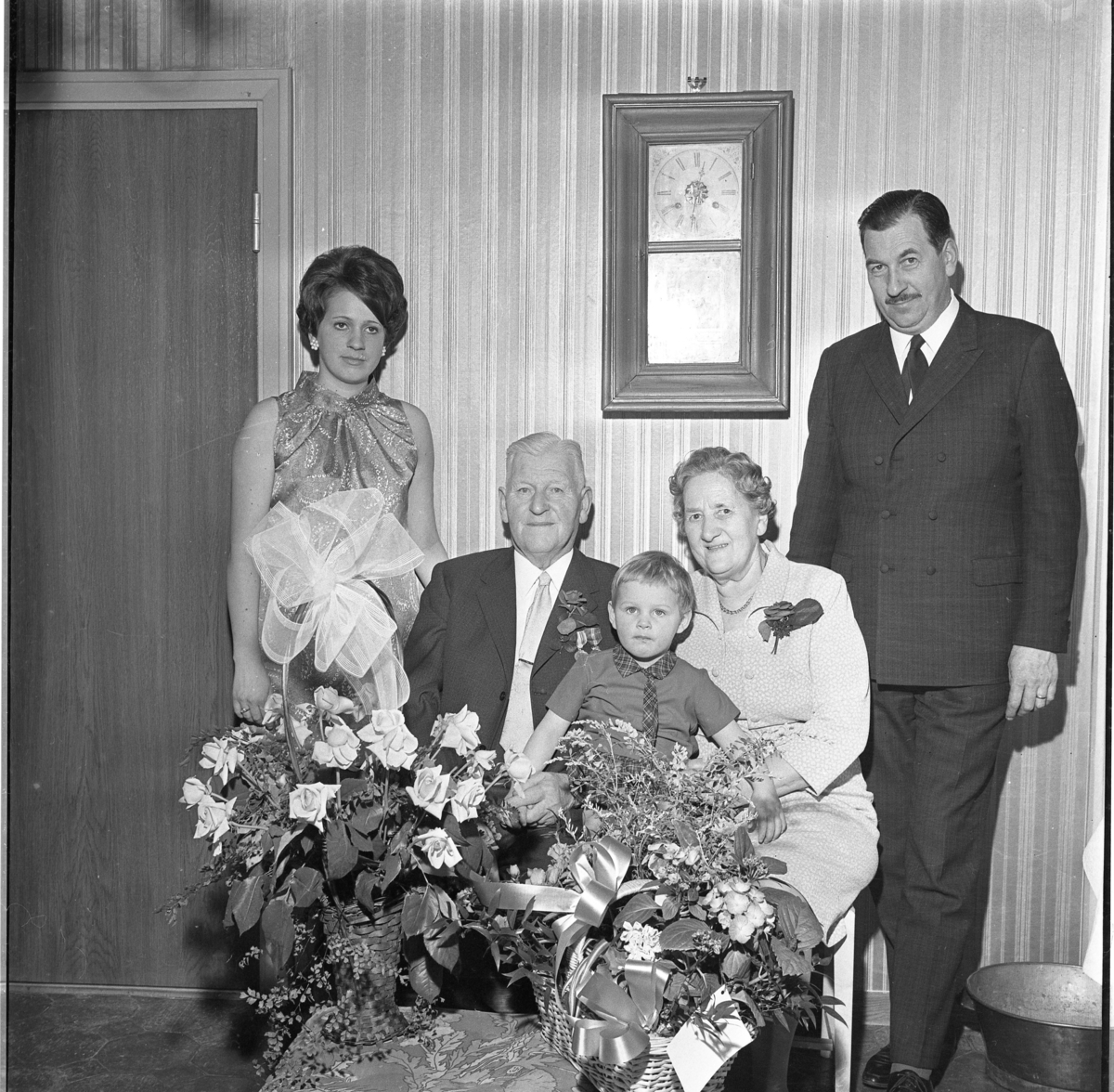 Gruppbild med fyra generationer Edberg. De äldre A T och Signe Edberg sitter bakom en bord med blombuketter. De flankeras av barnbarnet Agneta Blomberg till vänster och sonen Albert Edberg till höger. I Signes knä sitter barnbarnsbarnet Susanne.