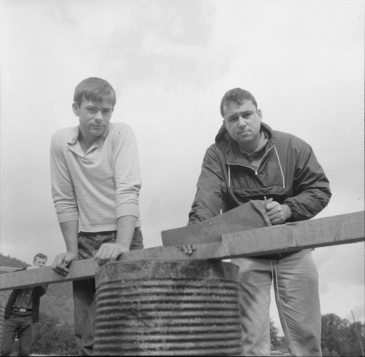 To ungdommer sager materiale til en bygning.
