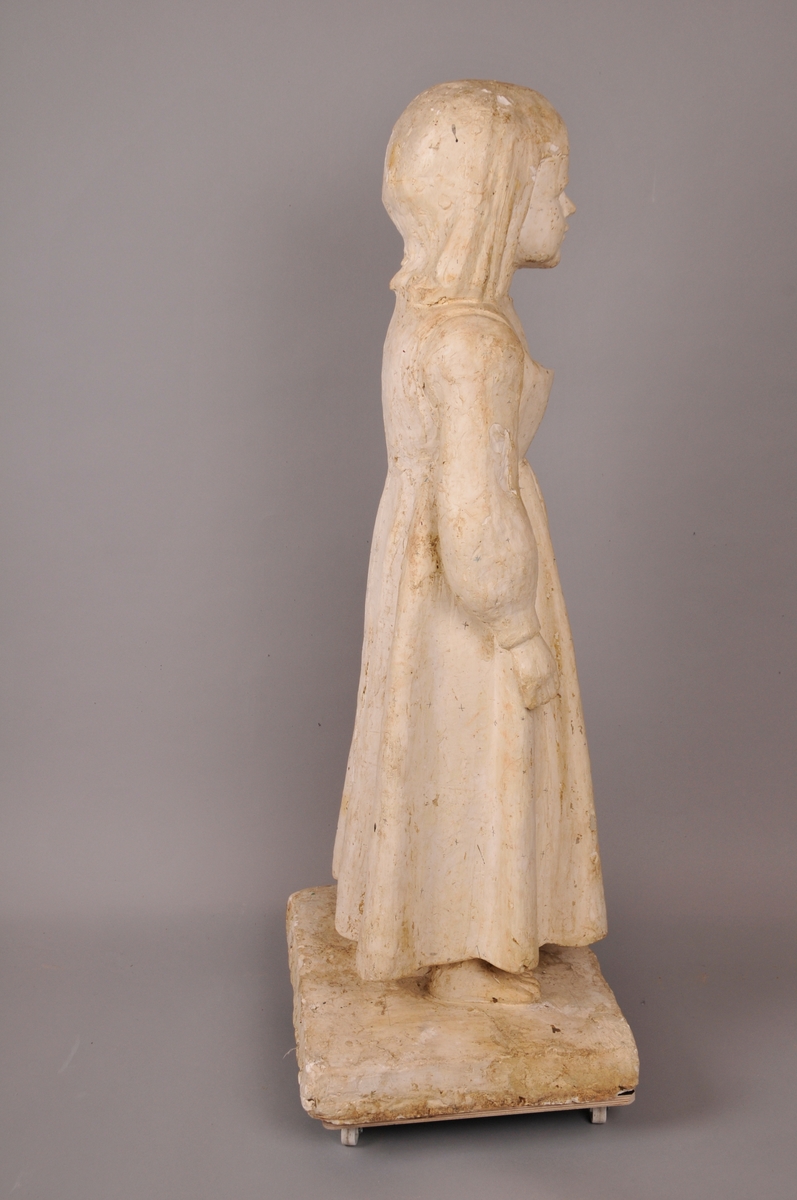 Skulptur, jente med eit brød i handa.