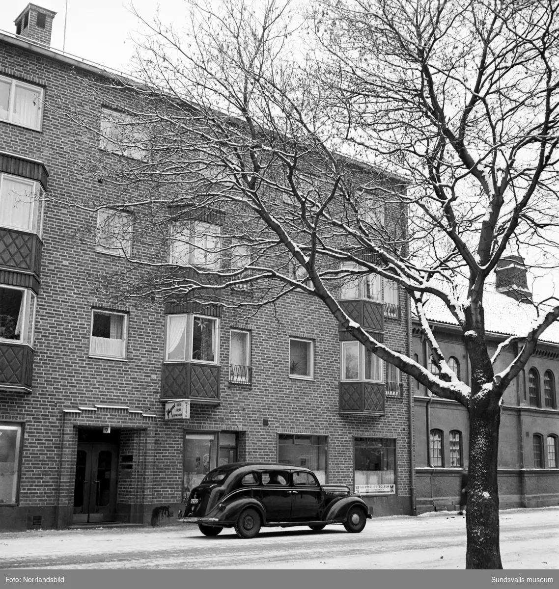 Fastigheten vid Trädgårdsgatan 45 och Köpmangatan 13. I gatuplan en skylt med texten "Yngves bröd, frukt, konfektyr".
