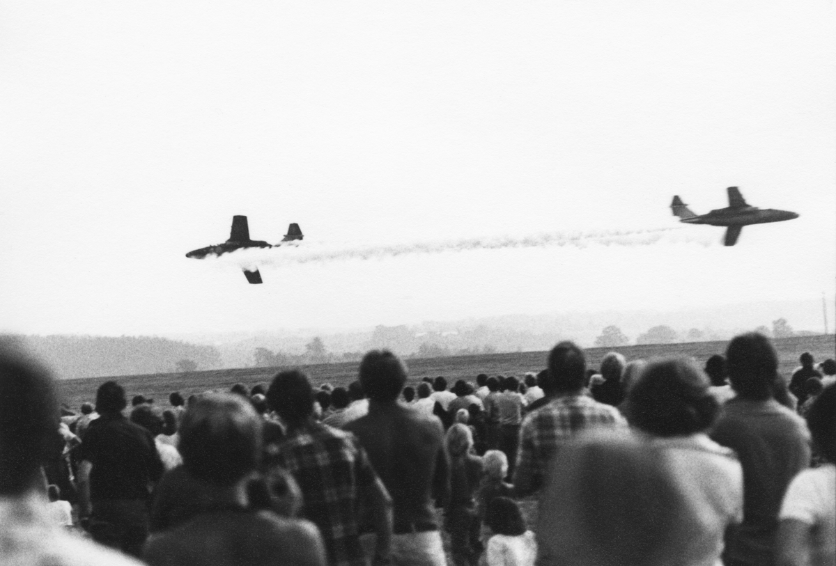 Avancerad flygning med två flygplan SK 60 ur Flygvapnets uppvisningsgrupp vid flygdagen på Malmen den 28 augusti 1976. Vid firande av Flygvapnet 50 år. Publik i förgrunden.